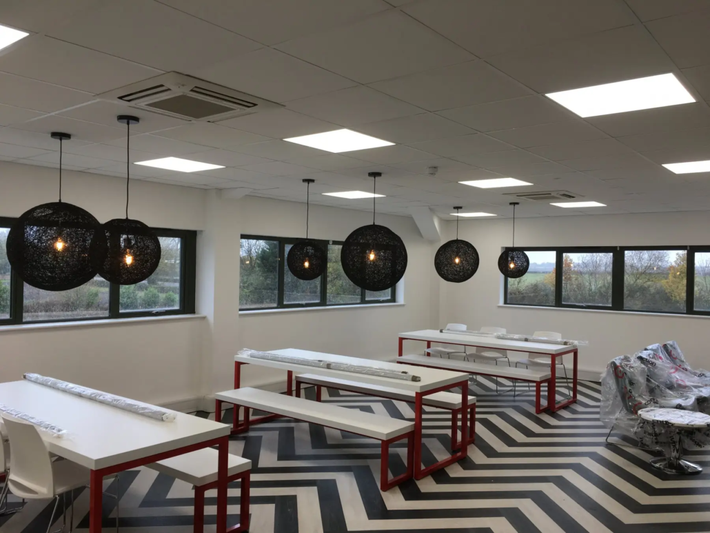 A staff canteen with pendant lights and LED panels